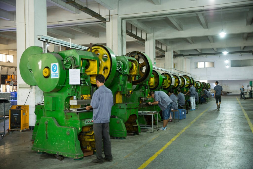 Workers operating the stamping line at Aluvox aluminum luggage factory