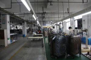 Production hall with finished luggage in protective covers moving toward the inspection area