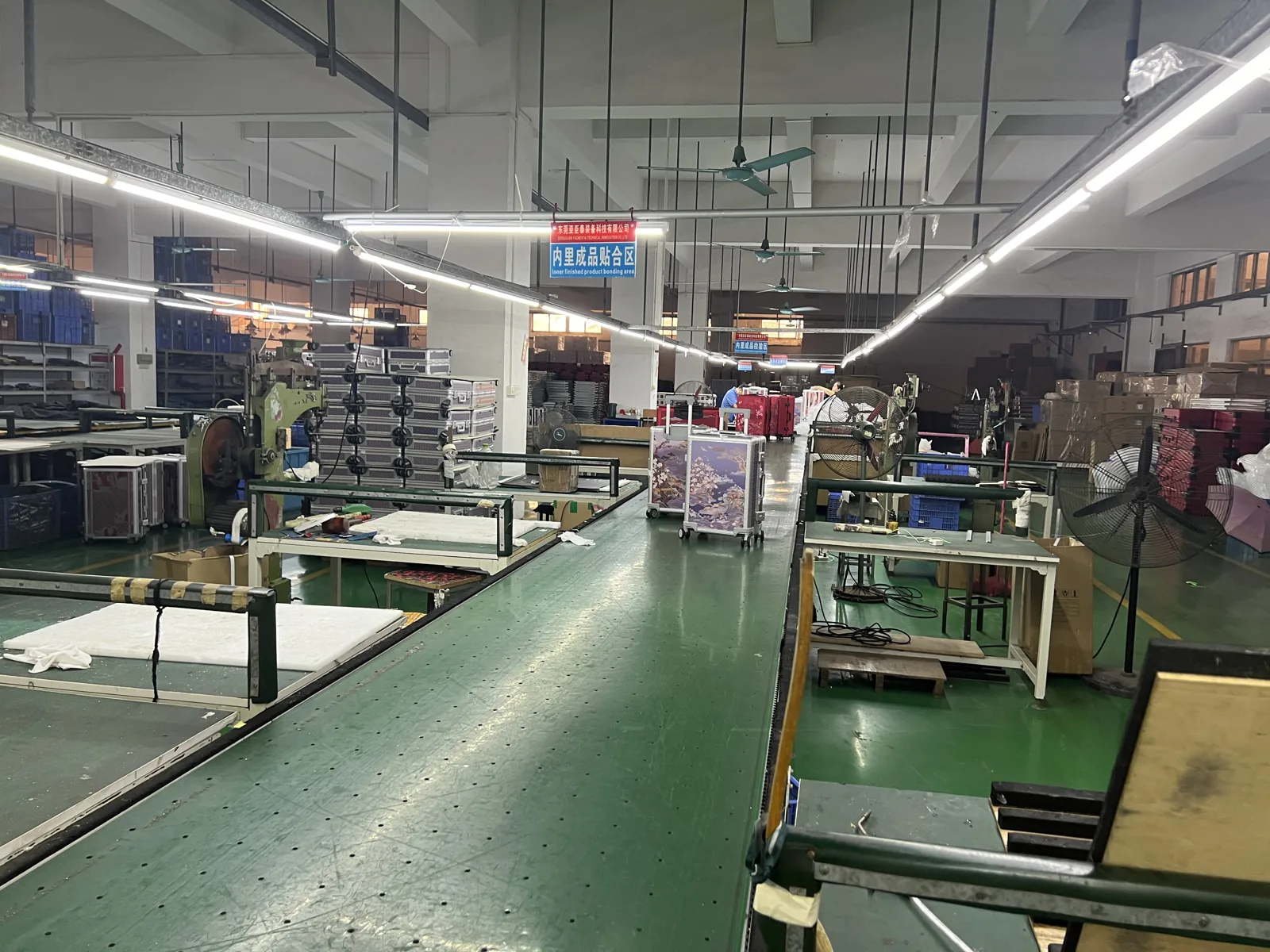 Lining and bonding area with long work tables, rolls of material and a trolley of components in the aisle