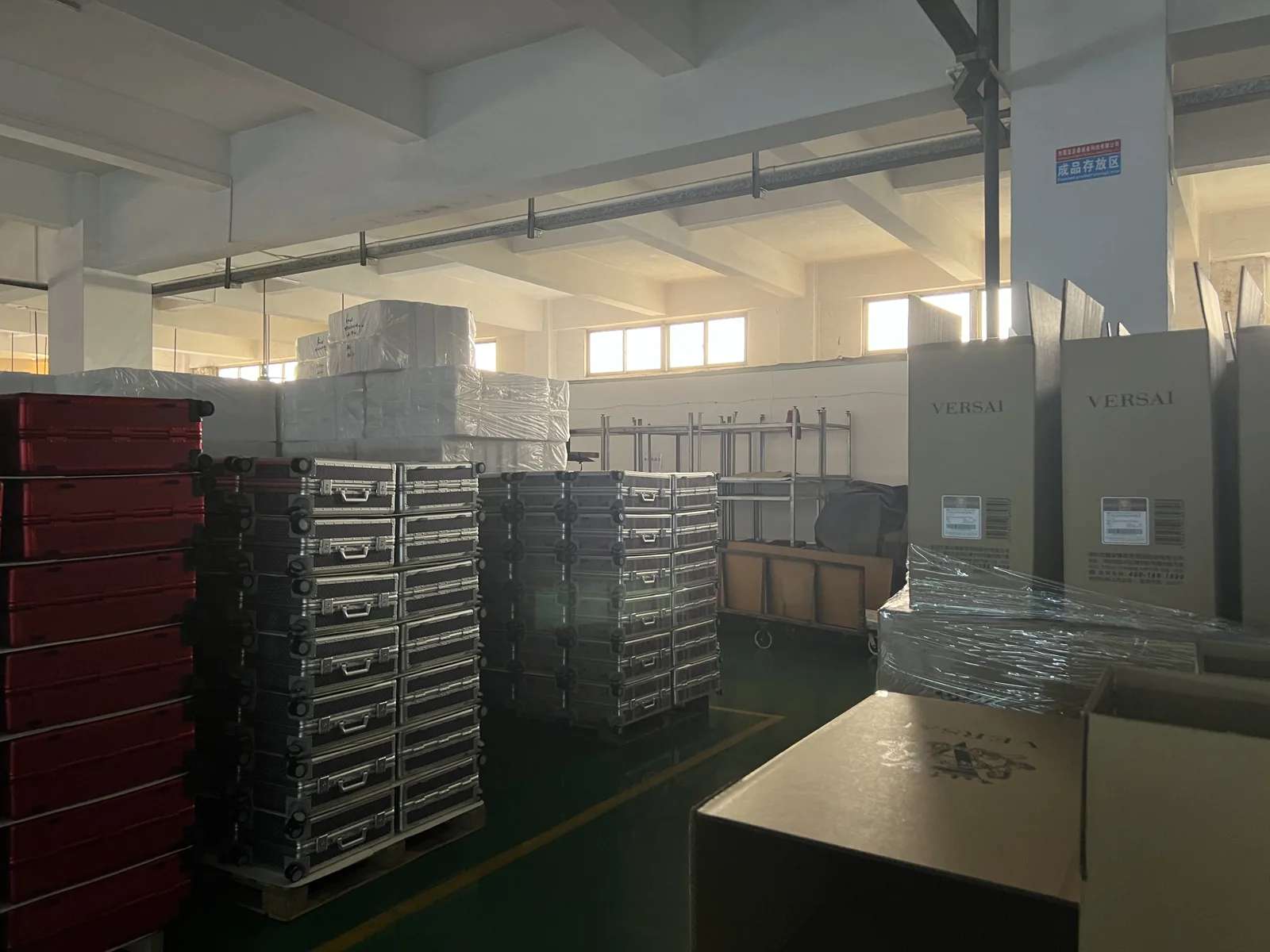 Finished goods storage area with stacked cases on pallets and labeled cartons wrapped in film