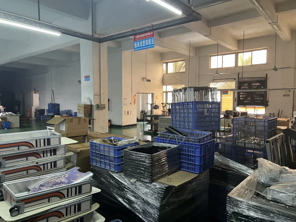 东莞工厂的装配成型区，铝框架外壳堆叠在一起等待组装。