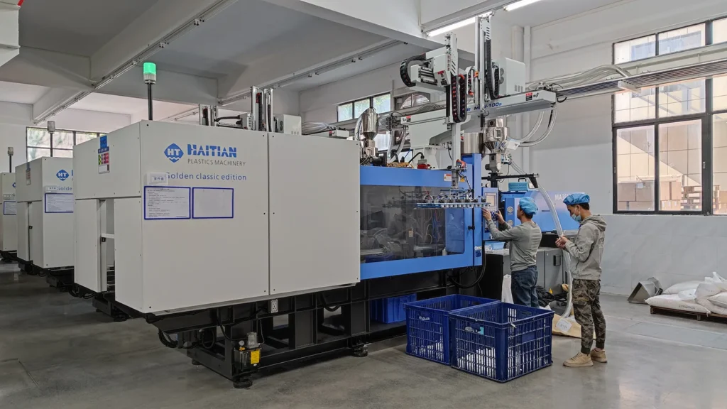 Row of Haitian injection molding machines with robot take-out arms running plastic luggage components