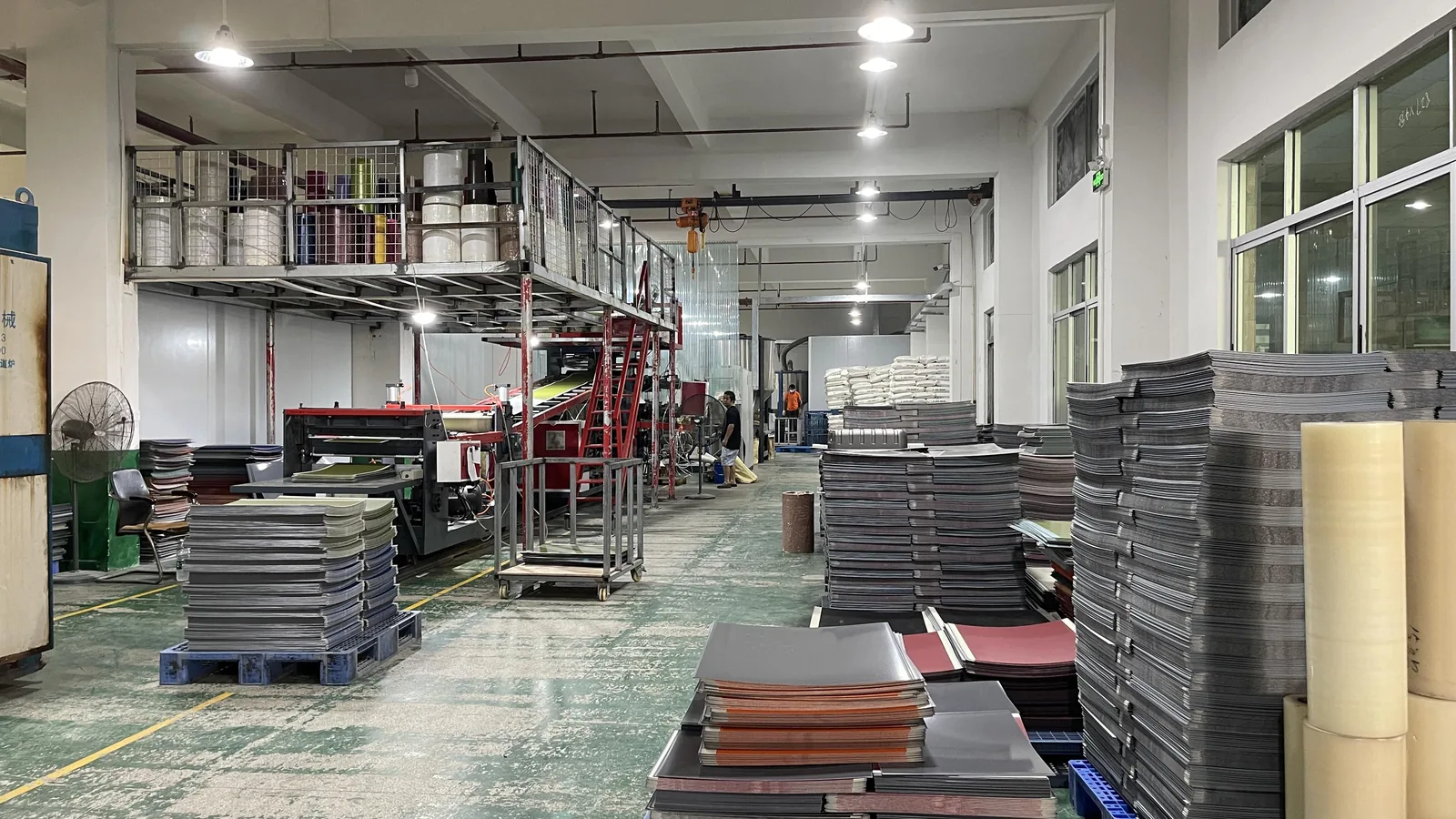 Plastic sheet extrusion line and stacks of cut sheet in several colors used for thermoformed luggage shells