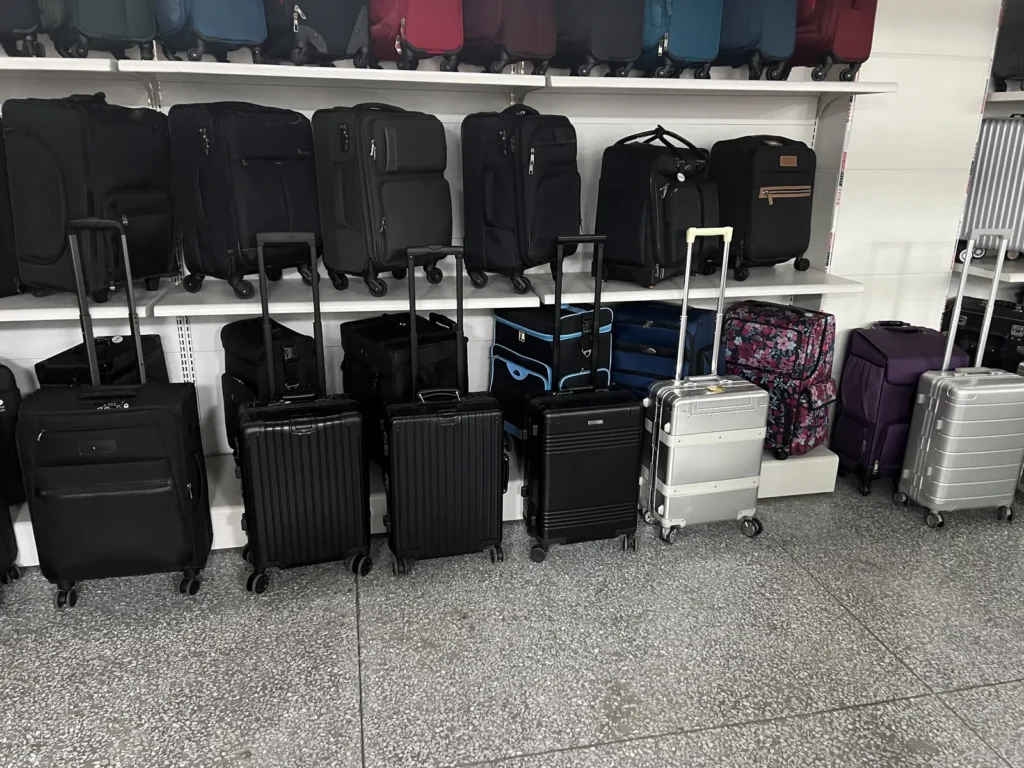 Showroom wall of finished luggage across hard shell, aluminum frame, and soft side models in several sizes