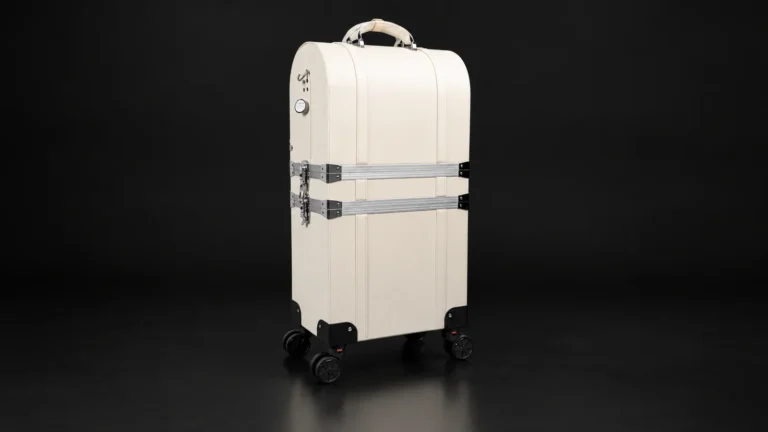 Cream two-tier makeup trolley case with aluminum straps from the Aluvox factory, studio shot on black