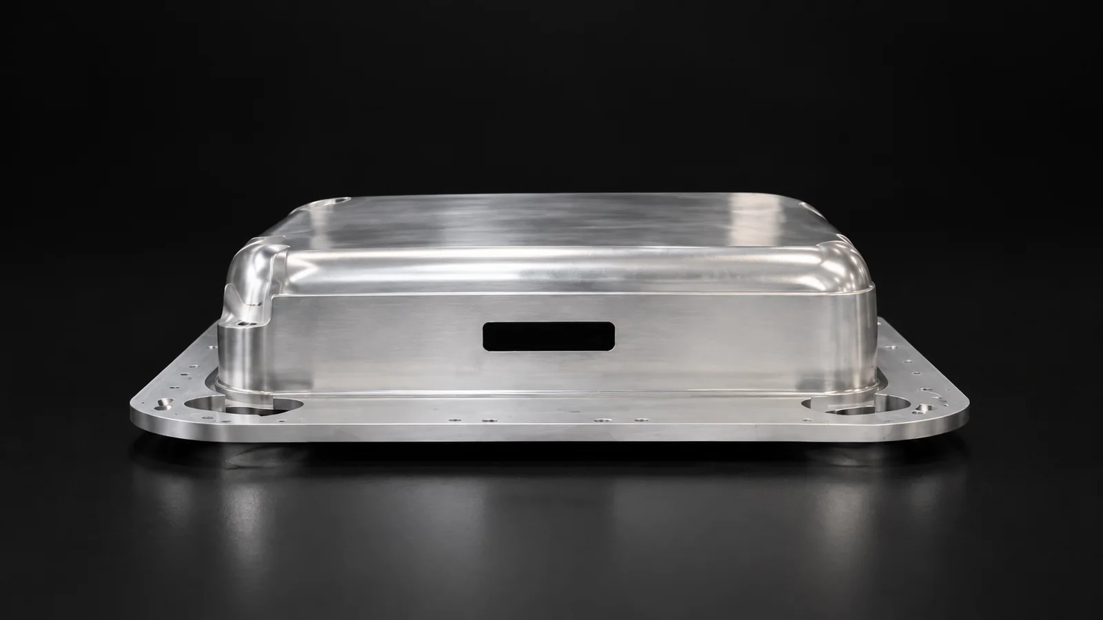 Silver aluminum component with a raised profile and perimeter openings on a black background