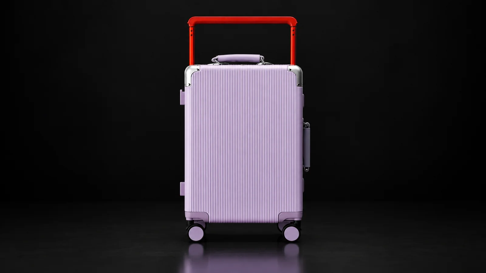 Lavender ribbed polycarbonate zipperless suitcase with red telescopic handle from the Aluvox range, studio shot on black