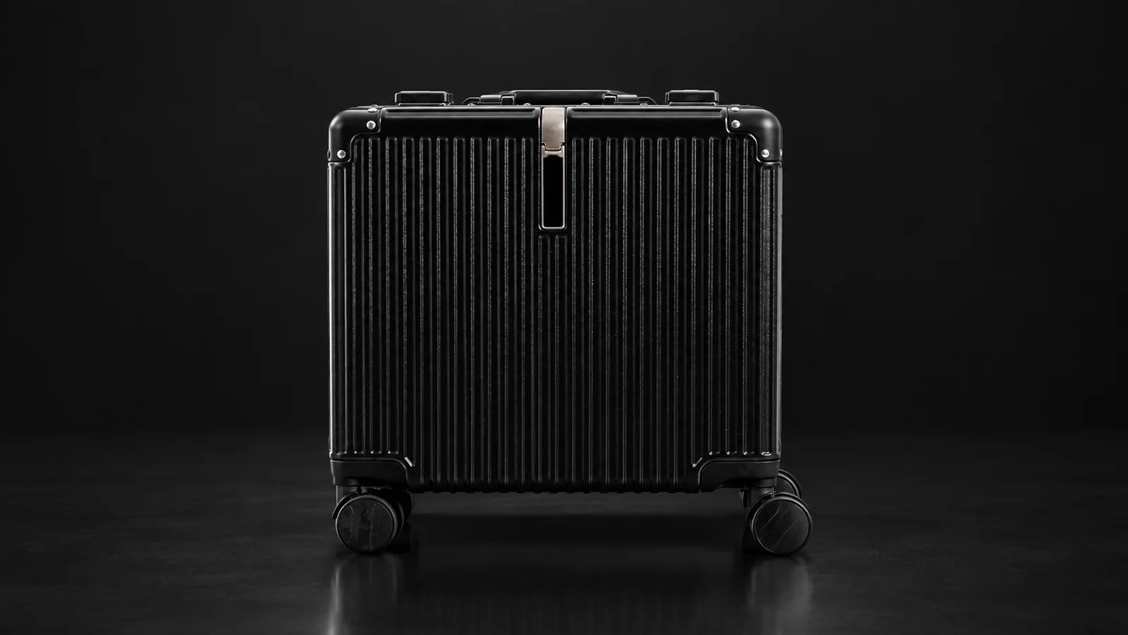 Black ribbed polycarbonate suitcase from the Aluvox range, front view, studio shot on black