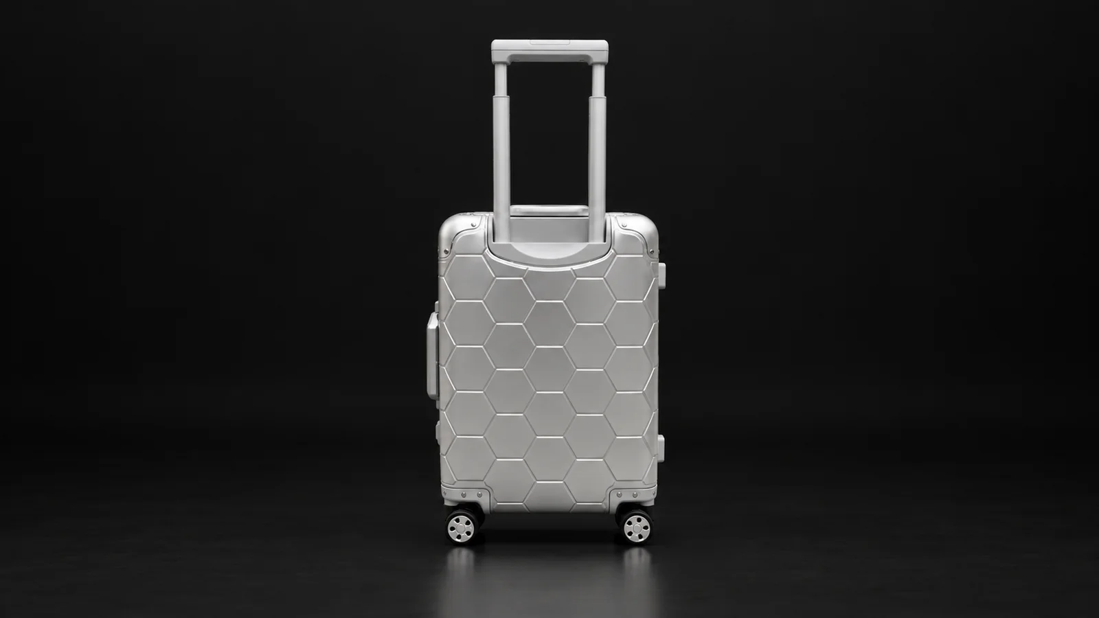 Silver hexagon-textured aluminum suitcase from the Aluvox factory, studio shot on black