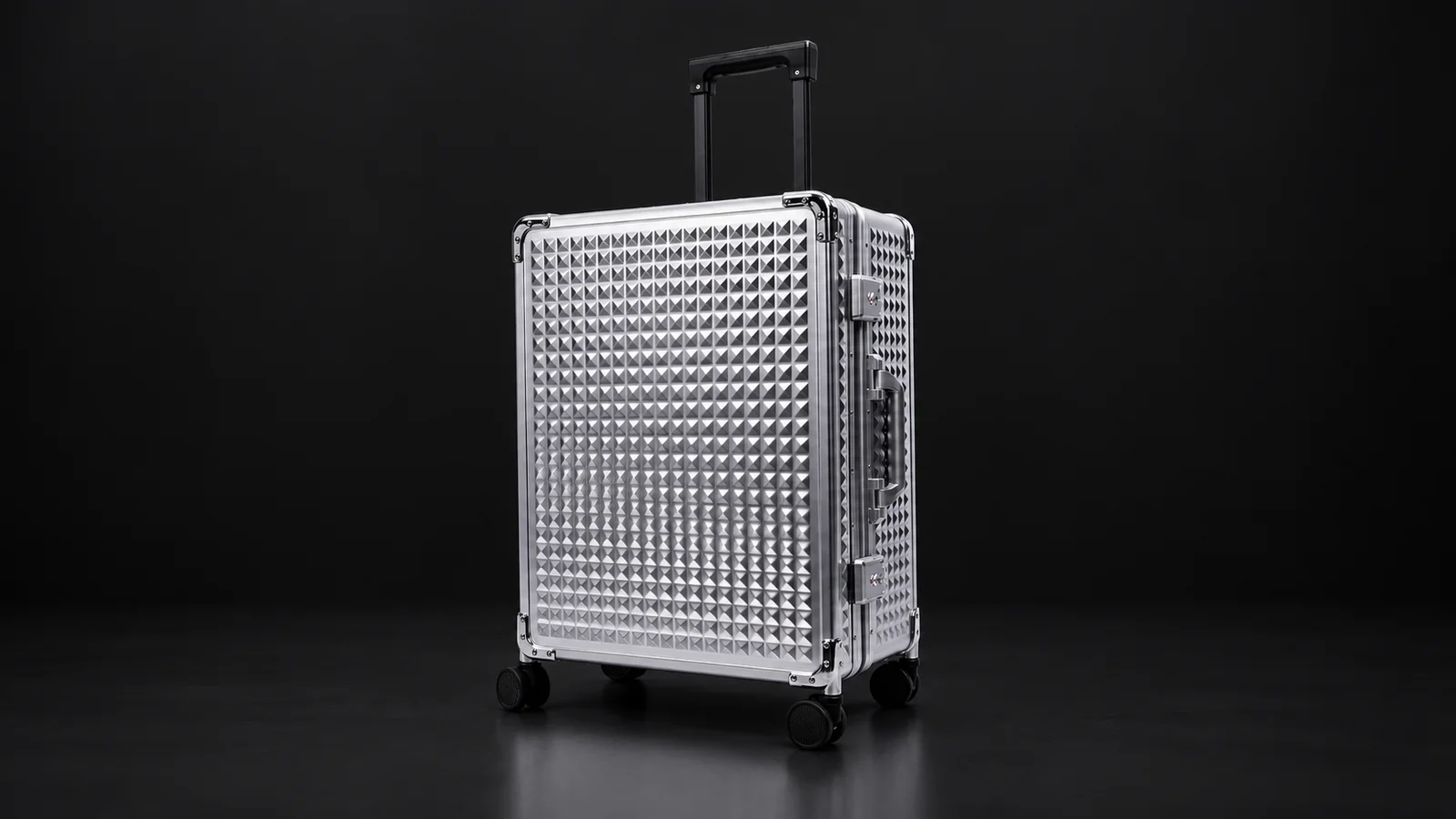 Silver diamond-textured aluminum suitcase from the Aluvox factory, studio shot on black