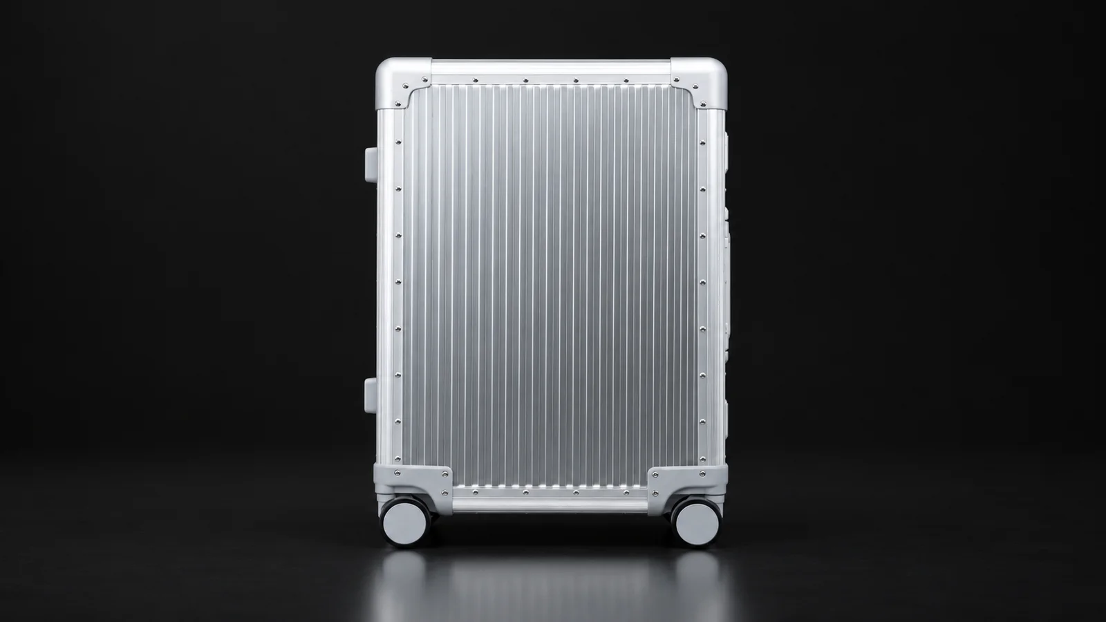 Silver ribbed aluminum suitcase, front view, from the Aluvox factory, studio shot on black