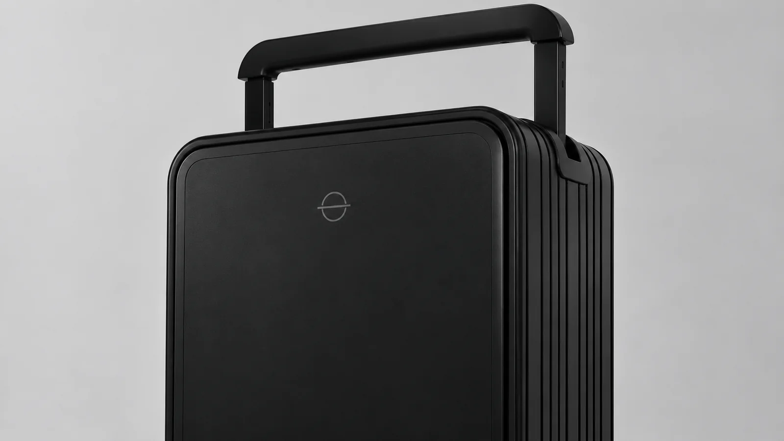 Laser-marked logo on the front panel of a black aluminum suitcase